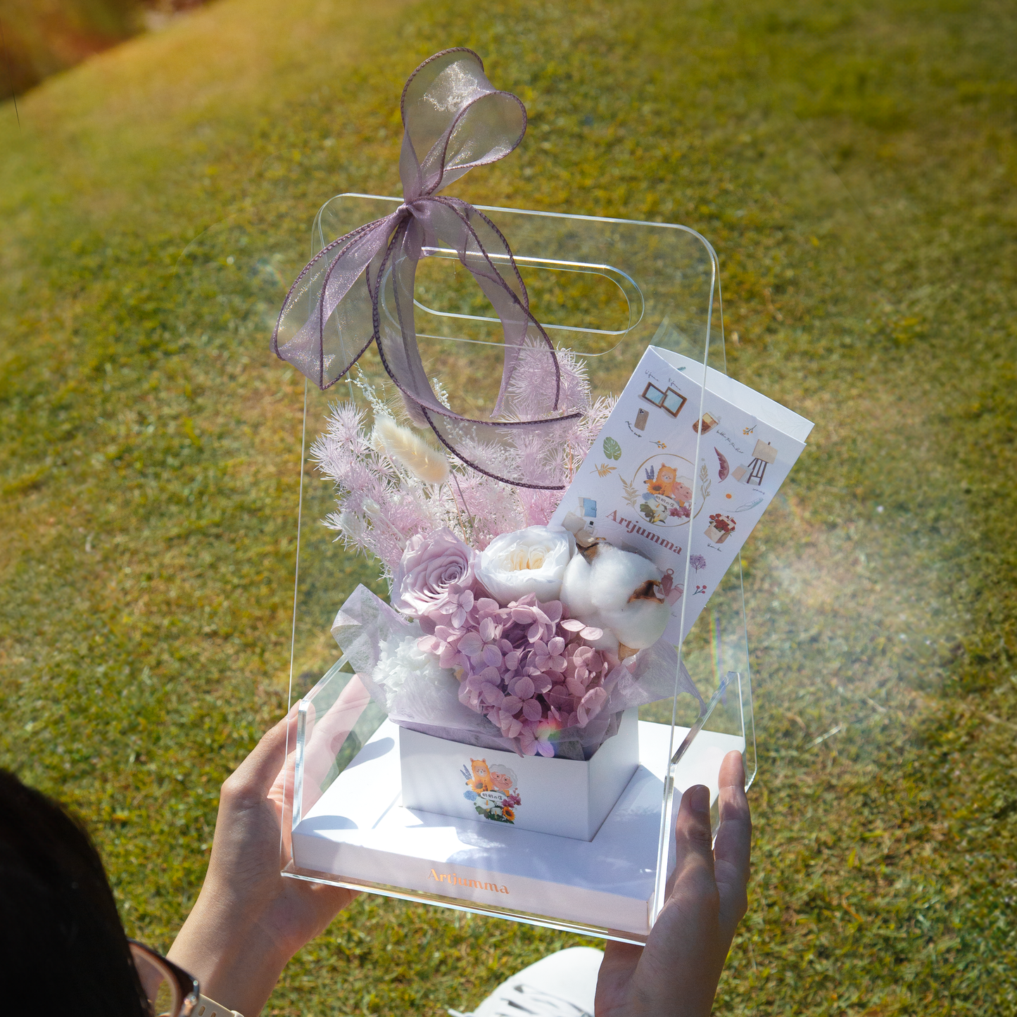 Pink party supply gift box with cut flowers.