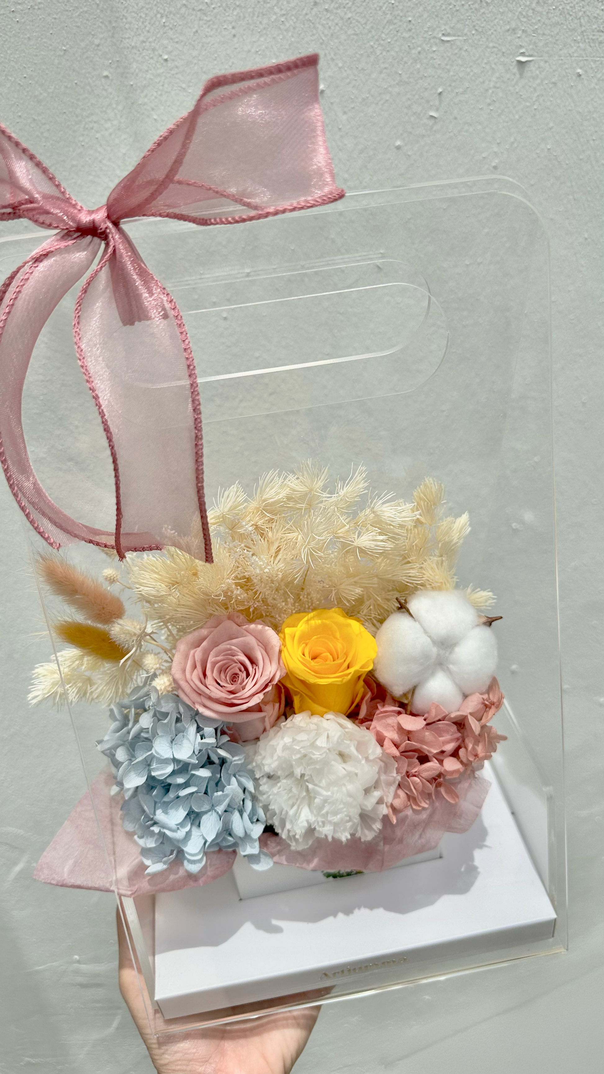 Pink flower bouquet with artificial flowers and paper wrapping.
