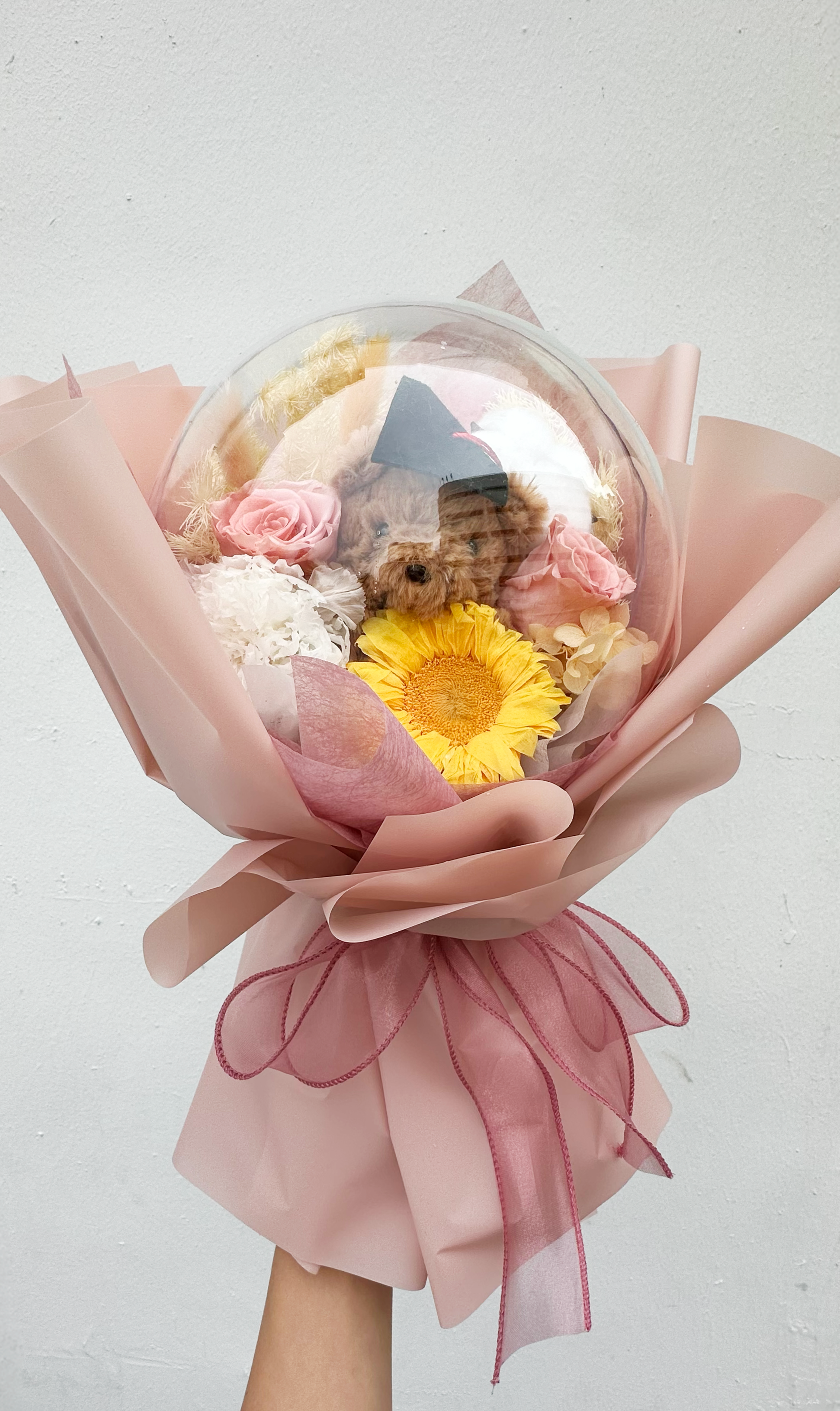 Pink artificial flower bouquet with petals.