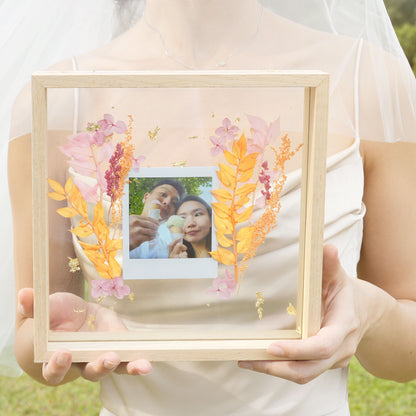 square frame with polaroid and pressed flower